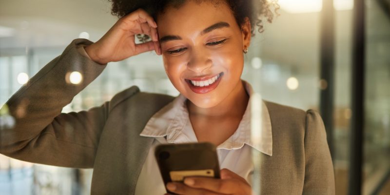Business woman on a phone networking on social media, reading a blog or research in corporate offic Business woman on a phone networking on social media, reading a blog or research in corporate offic